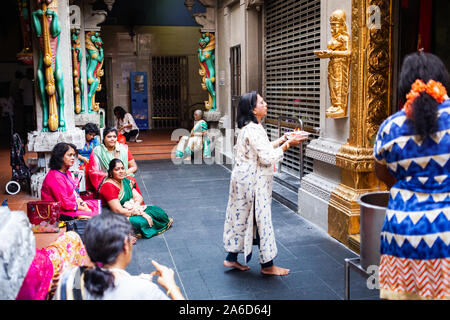 SINGAPORE, SINGAPORE - MARCH 2019: Hindu woman practicing her religion in a templein Singapore. Singapore is an example of multiculturalism with many Stock Photo