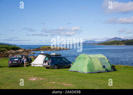 Family camping holidays at the Eagle Point Camping site near Bantry , West Cork, Ireland. Tents are being set up at the banks of Bantry Bay. Stock Photo