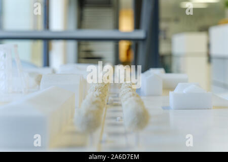 Close up and selected focus on white architectural model are made with foam board, and background of blur architect office atmosphere. Stock Photo