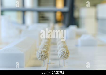 Close up and selected focus on white architectural model are made with foam board, and background of blur architect office atmosphere. Stock Photo
