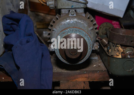 Old rusty selfmade bench grinder on the workbench Stock Photo