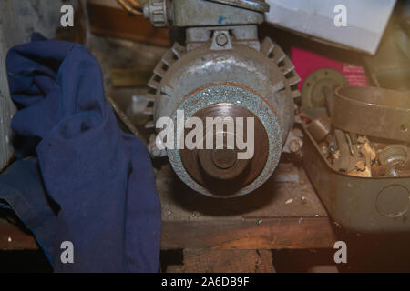Old rusty selfmade bench grinder on the workbench with lens flare Stock Photo
