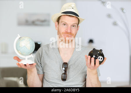 confused traveler with globe and savings Stock Photo