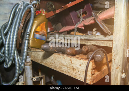 Old instruments on the rack in the old workshop with lens flare Stock Photo