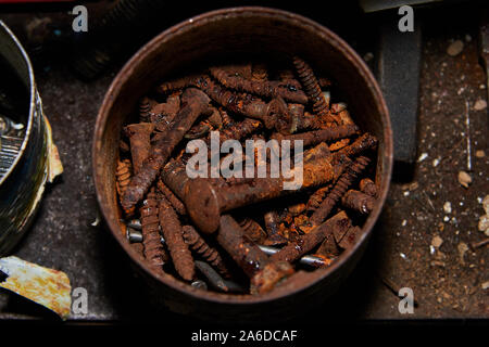 Rusty bolts and screws in metal box on the metal staple closeup. Stock Photo