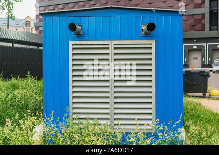 Blue heating station building with grey ventilation grid in the city Stock Photo
