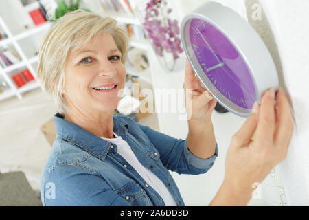 senior woman holding clock Stock Photo