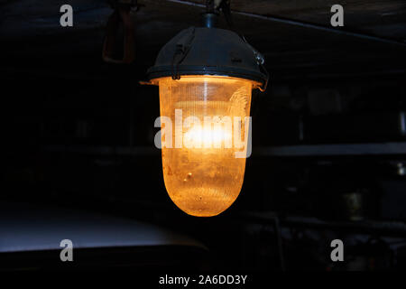 Old yellow lantern under the ceiling in the dark Stock Photo