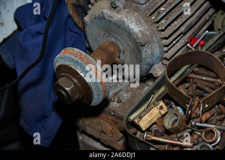Old rusty selfmade bench grinder on the workbench Stock Photo