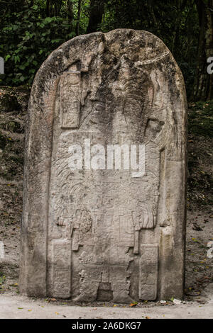 Stela 16 stone carving shows ruler Hasaw Kan K’awil in elaborate ritual dress.  Tikal National Park, Guatemala. A UNESCO World Heritage Site. Stock Photo