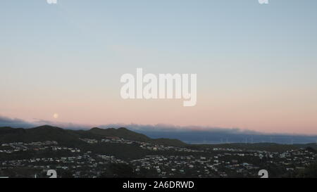 Full moon sets in the west over Wellington suburbs on a spring morning Stock Photo