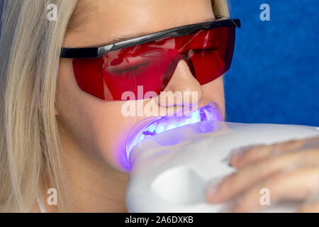 close-up portrait of girl on UV teeth whitening Stock Photo