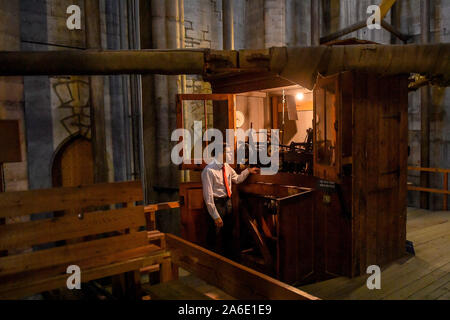 Salisbury Cathedral Verger Joseph Davies checks and adjusts the chiming clock, dated 1883, that strikes the bells at the top of the clock tower, as part of the maintenance and adjustments ahead of the clocks going back an hour to mark the end of British Summertime. Stock Photo