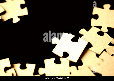 Puzzles scattered on a black surface close up. Abstract background Stock Photo