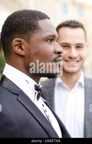Focus on afro american and smiling caucasian men wearing suits. Stock Photo