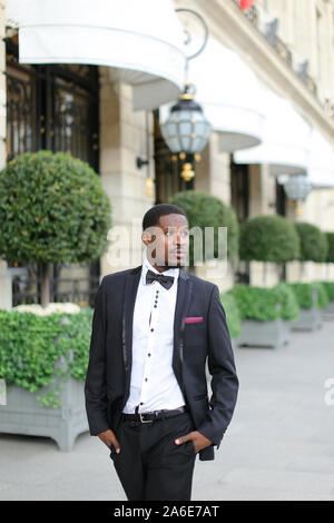 Afro handsome american man wearing suit and standing near building. Stock Photo