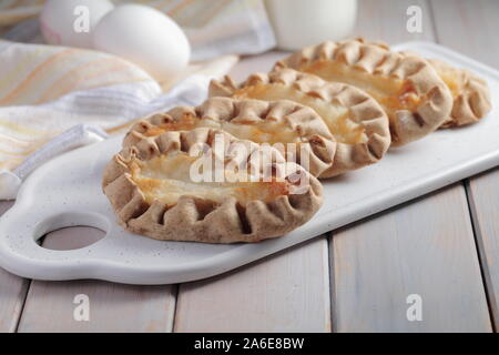 Karjalanpiirakat, Karelian pasties on a cutting board against eggs. Today it is a national dish in Finland Stock Photo