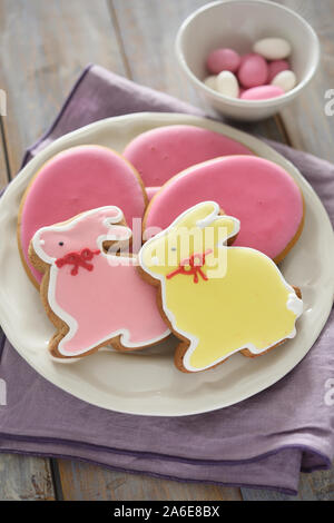 Easter sweets including bunny cookies and egg candy on a rustic table Stock Photo