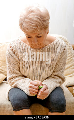 Lonely senior woman with depression sitting in home. Suffering of grief. Stock Photo