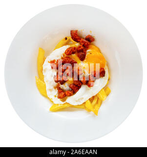 Top view of popular Spanish dish of broken eggs served with fried chistorra and potatoes. Isolated over white background Stock Photo