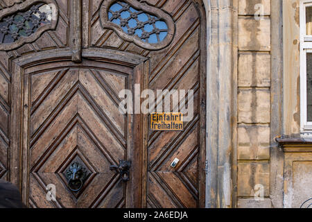 Old wooden door with sign in German 'Einfahrt freihalten' - Translation 'keep the driveway free Stock Photo