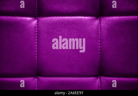 Shiny dark lilac artificial textured leather stitched with thread. Close-up of sofa surface. View from directly above. Highly detailed background with Stock Photo
