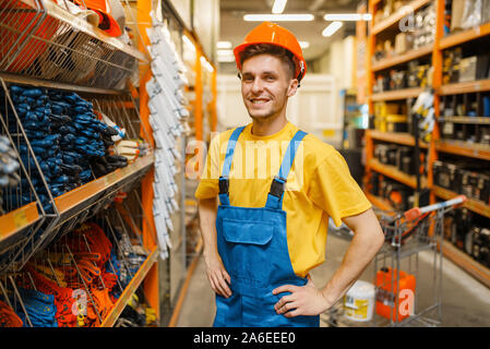 Male builder trying on helmet in hardware store Stock Photo