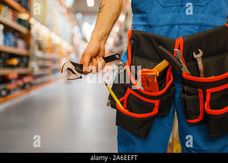Male builder choosing tool belt in hardware store Stock Photo