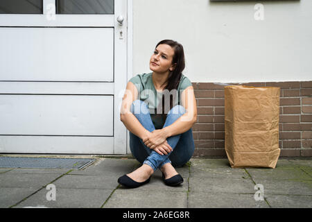 Young Woman Waiting In Front Of Closed Door Stock Photo