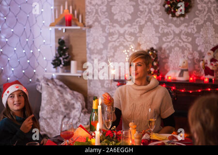Caucasian beautiful mother and her daughter at family christmas celebration. Alcohol for christmas celebration. Happines at chrismas festive dinner. Stock Photo