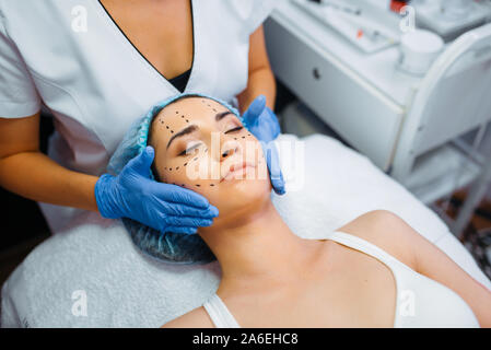 Cosmetician makes botox injection in dotted lines Stock Photo