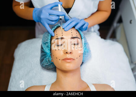 Cosmetician makes botox injection in dotted lines Stock Photo