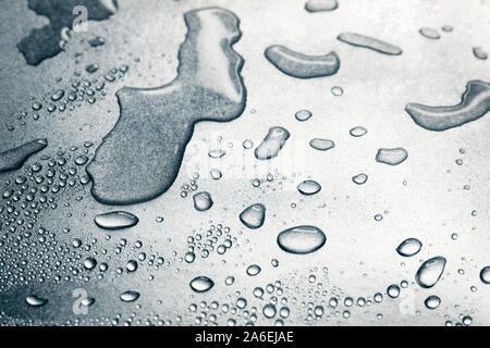 Water drops on rough silvery background, close-up Stock Photo