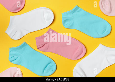 Multi-colored socks on a yellow background. Top view. Stock Photo