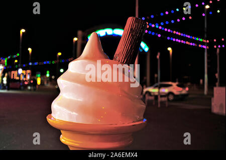 Giant plastic ice cream cone with Blackpool illuminations in the background Stock Photo