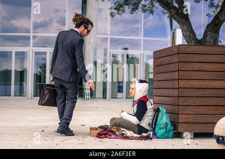 Businessman helps a homeless giving money - business, people and lifestyle concept - caucasian people Stock Photo