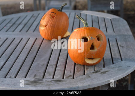 Carved Pumpkins, Smiling, on a Table Out of Doors Facing and Side