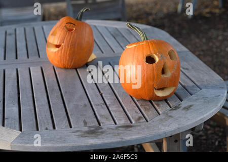 Carved Pumpkins, Smiling, on a Table Out of Doors Facing and Side