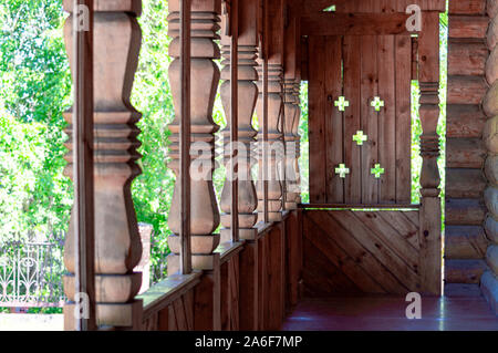 Wooden architecture. Fragment of the porch of an old Christian temple. Carved columns. View along. Stock Photo