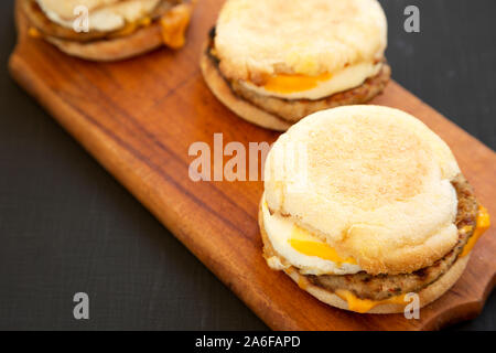 Homemade pork roll egg sandwich on a rustic wooden board on a black background, side view. Closeup. Stock Photo