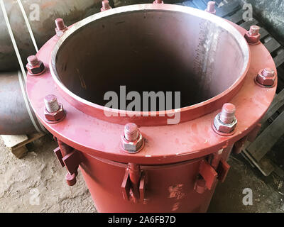 Red gland expansion joints for heating main on concrete floor. Heat and power concept. Stock Photo