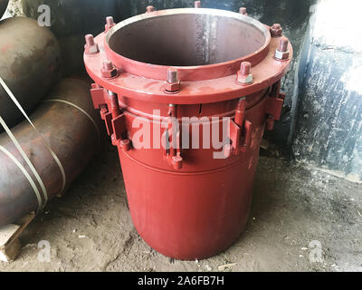 Red gland expansion joints for heating main on concrete floor. Heat and power concept. Stock Photo