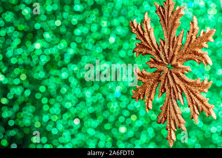 golden snowflake on green bokeh background, christmas card decoration with copy space Stock Photo