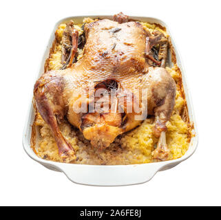 baked duck stuffed with apples and millet porridge in ceramic pan cutout on white background Stock Photo