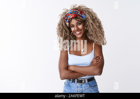 Charismatic african-american female bartender with blond curly afro hairstyle, listening interesting funny story as pouring drink customer, cross Stock Photo