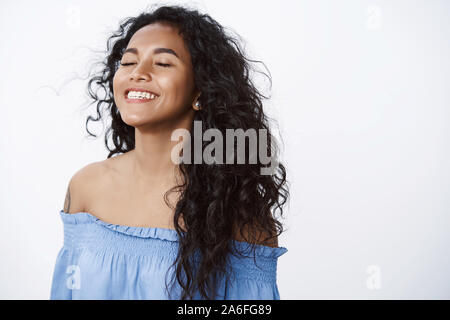 Close-up free and relieved happy attractive, encouraged african american curly-haired woman with tattoos in blue blouse, inhale fresh air close eyes Stock Photo