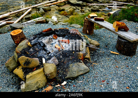 A circle of rocks made to incircle a campfire on a beach on the rocky shore on Vancouver Island in British Columbia Canada. Stock Photo