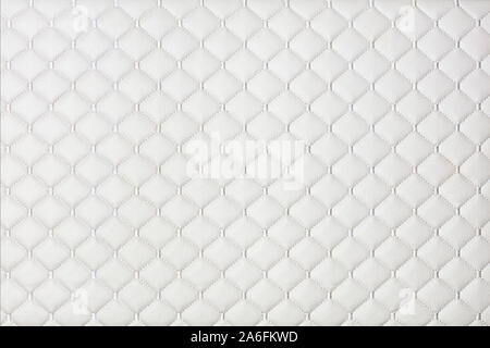 White leather furniture background and texture stitched with silver diamond-shaped threads. Stock Photo