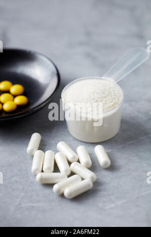 Collagen powder, Proline capsules and Vitamin C tablets. Supplements to support collagen production. Stock Photo