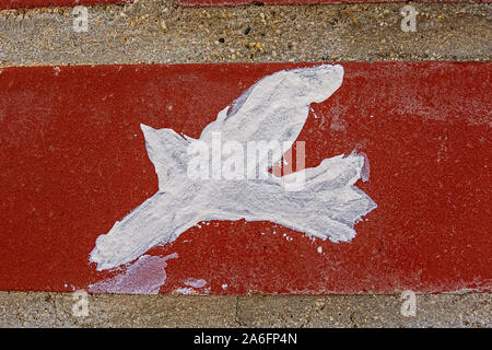 paint splashes looking like a bird  on a house wall gray with red stripe Stock Photo